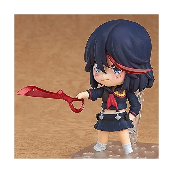 La poupée modèle Matoi Ryuuko version Q, le personnage de "The Killing Girl", debout, vêtue dune robe rouge avec un accessoi