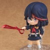 La poupée modèle Matoi Ryuuko version Q, le personnage de "The Killing Girl", debout, vêtue dune robe rouge avec un accessoi